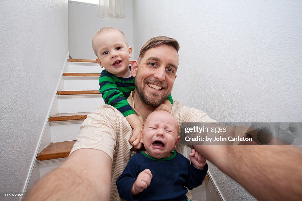 Dad and sons sitting in stairwell