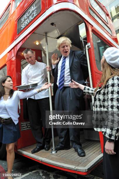 London Mayor Boris Johnson with celebrity chef Gary Rhodes standing on the open platform at the back of a historic Routemaster bus during a visit to...