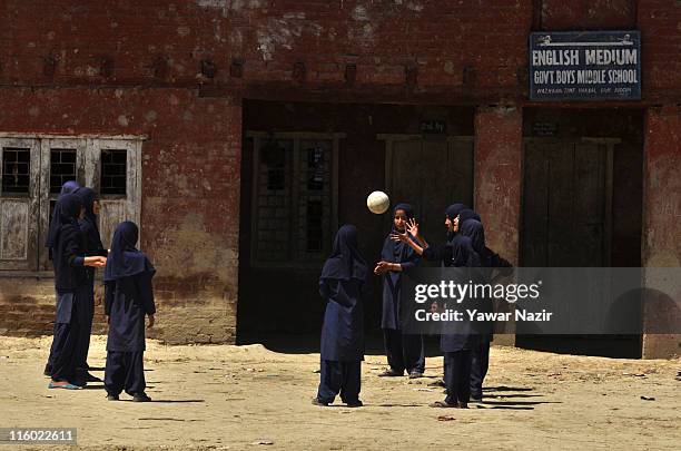 Kashmiri Muslim school girls play volley ball in the ground of their schoold during a break on June 14, 2011 in Budgam, 20 km west of Srinagar, the...