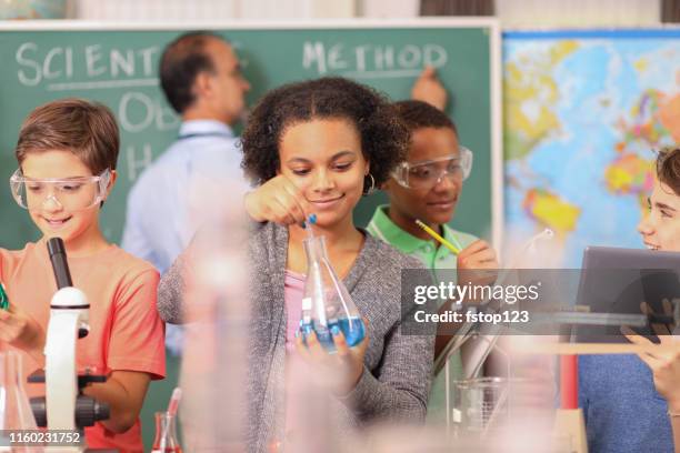 gli studenti delle scuole medie conducono esperimenti scientifici in classe. - ricerca di scienze foto e immagini stock