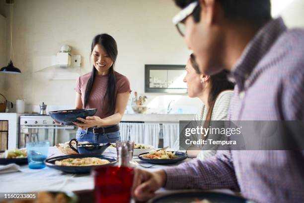 Mulher que traz o alimento à tabela.