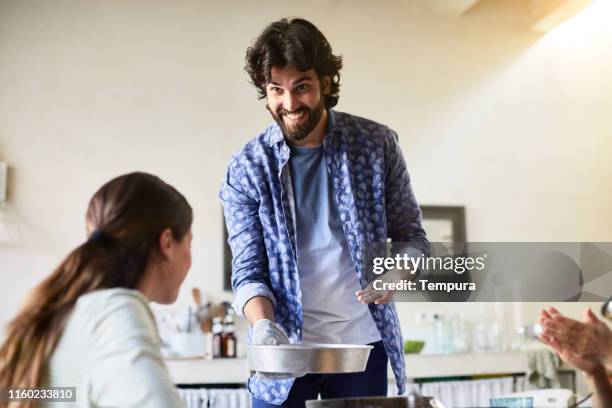 proudly showing baked food to his girlfriend. - serving dish imagens e fotografias de stock