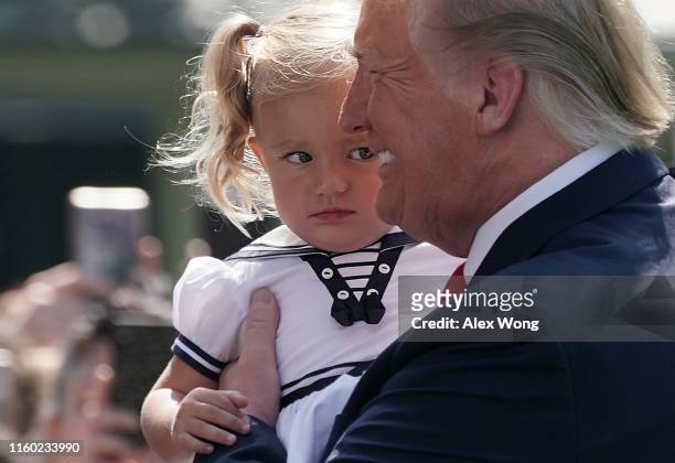 President Donald Trump holds a girl prior to his departure from the White House July 5, 2019 in Washington, DC. President Trump and the first lady...