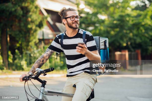 mann radfahren und sms - bicycle messenger stock-fotos und bilder