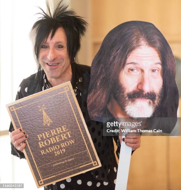 Air personality Jacky Bam Bam holds an oversized picture of WMMR air personality Pierre Robert as he speaks on Robert's behalf after he was announced...