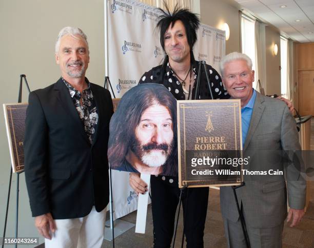 Program Director Bill Weston, and General Manager Joe Bell pose for a photo with air personality Jacky Bam Bam as he holds an oversized picture of...