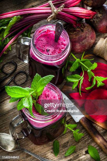healthy drink: beet juice on rustic wooden table - beetroot smoothie stock pictures, royalty-free photos & images
