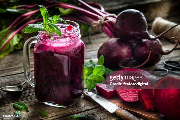 gesundes getränk: rübensaft auf rustikalem holztisch - beetroot juice stock-fotos und bilder
