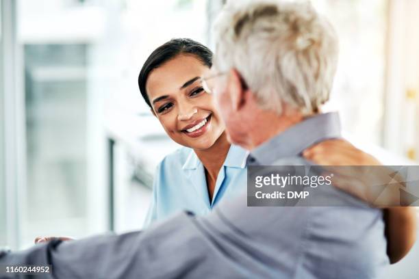support with a smile - nurse listening to patient stock pictures, royalty-free photos & images