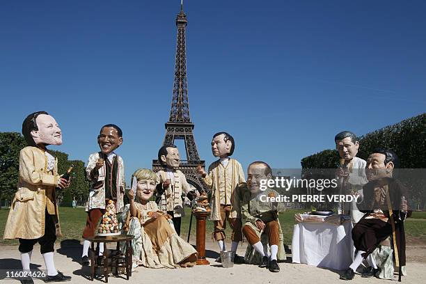 Activists of humanitarian NGO Oxfam wearing giant papier mache heads representing Prime minister of the United Kingdom David Cameron, President of...