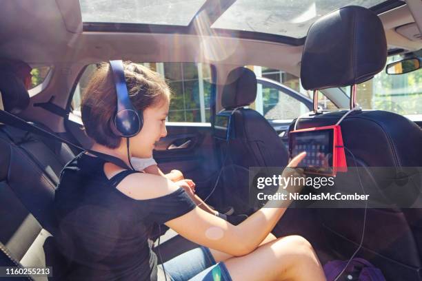 preteen mädchen mit tablet im auto bereit für einen roadtrip - girl in car with ipad stock-fotos und bilder