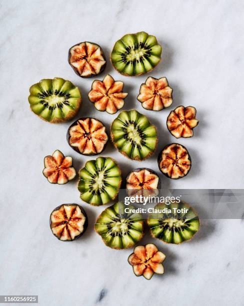 Slices of kiwi and figs on white background