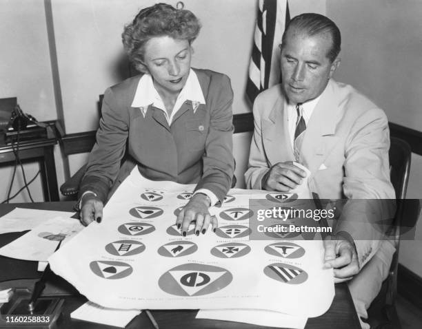 Alice Marble of California, Assistant Director of Civilian Defense in charge of physical training for women, confers with John B. Kelly of...