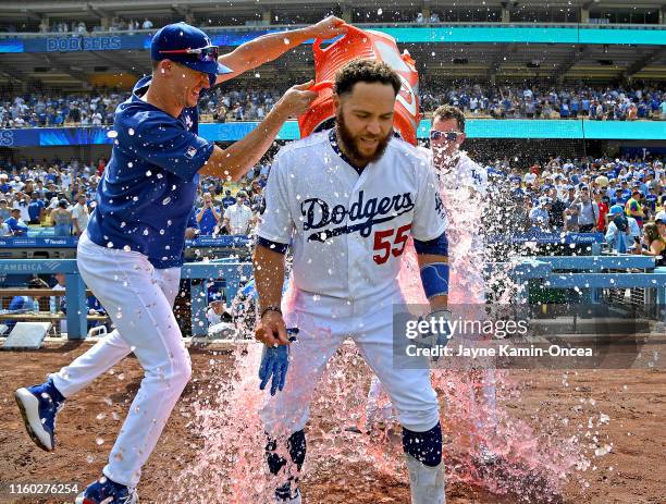 Russell Martin is drenched with a cooler of ice water by Walker Buehler and Joc Pederson as they celebrate his two RBI single for a walk-off win...