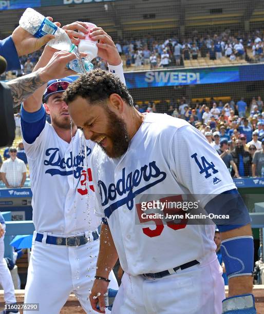 Russell Martin is drenched in ice water as Cody Bellinger of the Los Angeles Dodgers adds baby powder to the mix while they celebrate Martin's two...