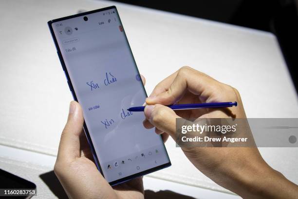 Man uses the stylus on the new Samsung Galaxy Note 10 smartphone during a launch event at Barclays Center on August 7, 2019 in the Brooklyn borough...