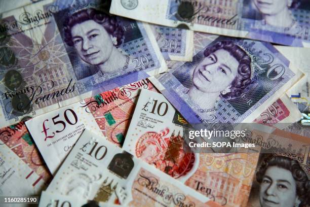 In this photo illustration, British Pound sterling banknotes are seen as Pound to US Dollar exchange rates are now trading close to a 2 ½ year low,...