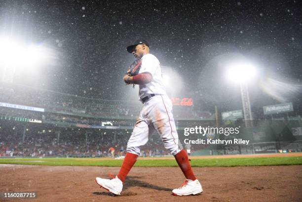 Mookie Betts of the Boston Red Sox heads back to the dugout after a rain delay is called in the tenth inning against the Kansas City Royals at Fenway...