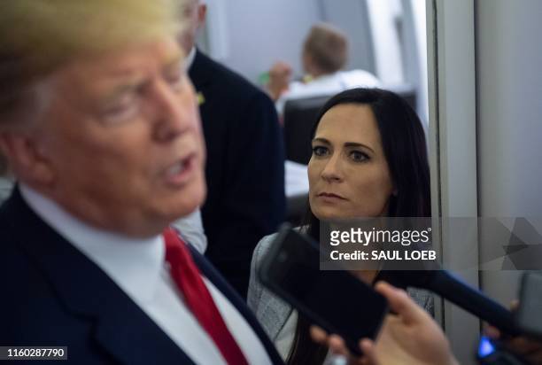 White House Press Secretary Stephanie Grisham listens as US President Donald Trump speaks to the media aboard Air Force One while flying between El...
