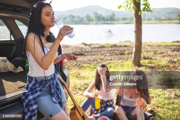young women, on a road trip, having fun in the nature - drinking soda in car stock pictures, royalty-free photos & images