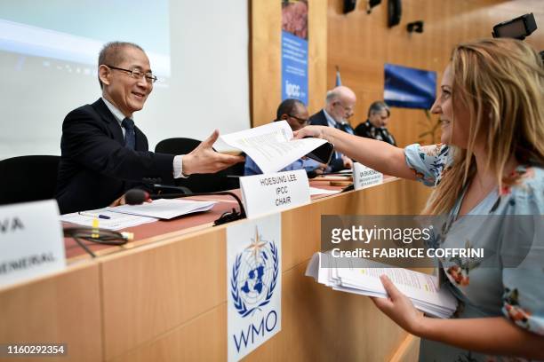 Intergovernmental Panel on Climate Change chairman Hoesung Lee receives a document prior to a press conference on a special IPCC report on climate...