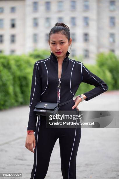 Guest is seen on the street during Berlin Fashion Week wearing black neoprene body suit with black belt bag and black heels on July 05, 2019 in...