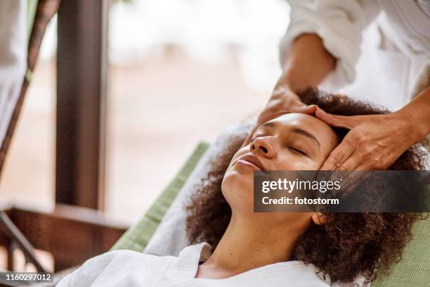 mujer relajándose durante el masaje de la cabeza - masaje fotografías e imágenes de stock