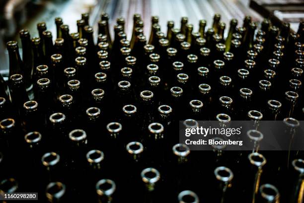 Unsealed bottles of Tuborg Green pilsner lager pass along the automated production line at the Carlsberg A/S brewery in Fredericia, Denmark, on...
