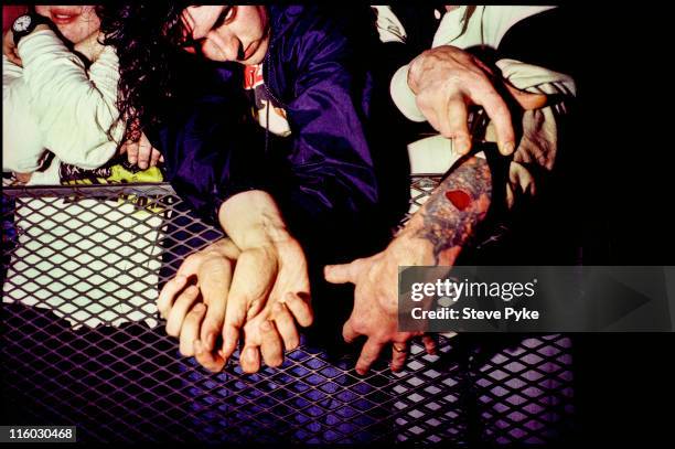 Member of the audience at a concert by American rock group Nirvana, shows off a tattoo, Belfast, 1992.