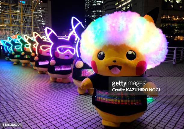 Performers dressed as Pikachu, the popular animation Pokemon series character, participate in a light performance during the Pikachu parade in...