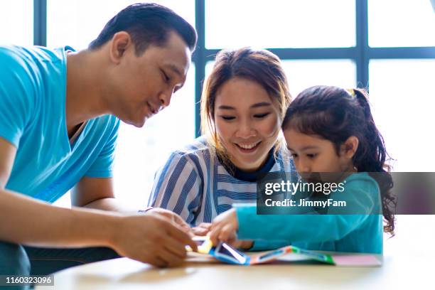 mixed race asian parents teaching daughter at home - malay archipelago stock pictures, royalty-free photos & images