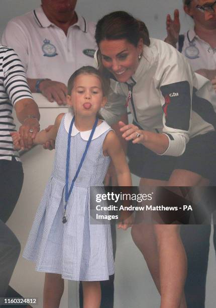 The Duchess of Cambridge with Princess Charlotte look through a window at the prize giving after the King's Cup regatta at Cowes on the Isle of Wight.