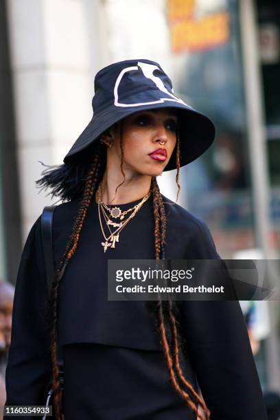 Twigs wears a Valentino hat, a black dress, necklace, earrings, outside Valentino, during Paris Fashion Week -Haute Couture Fall/Winter 2019/2020, on...