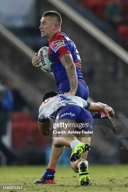 Shaun Kenny-Dowall of the Newcastle Knights is tackled by Kodi Nikorima of the New Zealand Warriors during the round 16 NRL match between the...