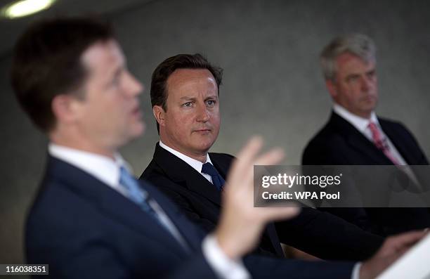 Prime Minister David Cameron listens beside Health Secretary Andrew Lansley while Deputy Prime Minister Nick Clegg speaks as they address hospital...