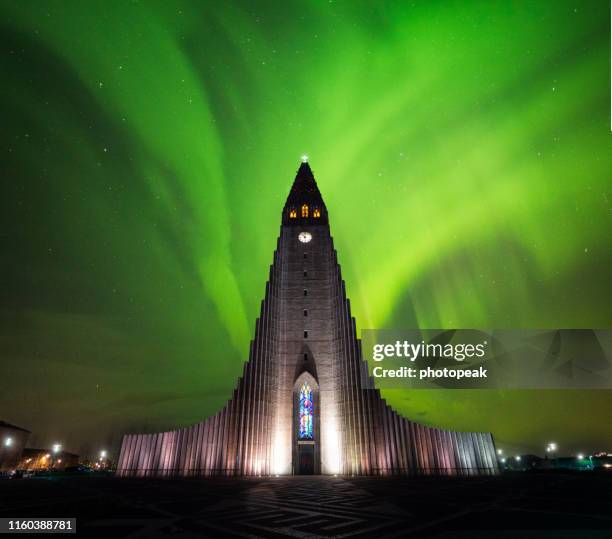 aurora borealis above hallgrimskirkja church in central of reykjavik city capital city in iceland - reykjavik hallgrimskirkja stock pictures, royalty-free photos & images