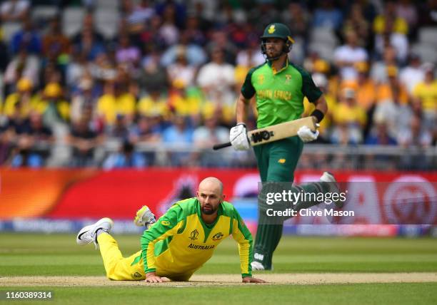 Nathan Lyon of Australia looks on as Quinton de Kock of South Africa and Aiden Markram of South Africa score during the Group Stage match of the ICC...