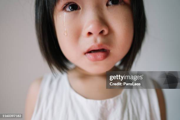 portrait of real asian child girl crying - teardrop stockfoto's en -beelden