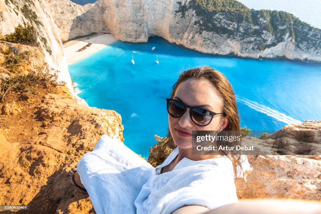 Woman taking a selfie from viewpoint of the famous shipwreck beach in Greece.
