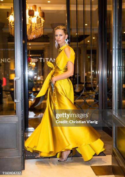 Karolina Kurkova is seen wearing yellow dress with slit, denim jeans on her way to the Vogue Party during Berlin Fashion Week on July 05, 2019 in...