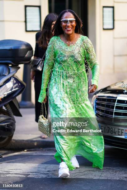 Michelle Elie wears a silver headband, a green lustrous dress, a bag, whit, outside Valentino, during Paris Fashion Week -Haute Couture Fall/Winter...