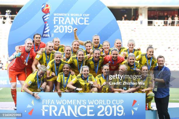 Players and coach of Sweden celebrate during the award ceremony after the 2019 FIFA Women's World Cup France 3rd Place Match match between England...