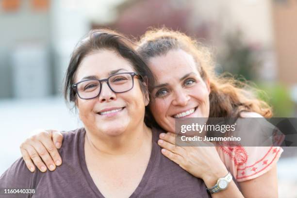 mature lesbian multi ethnic couple posing at their home front door - fat lesbian stock pictures, royalty-free photos & images