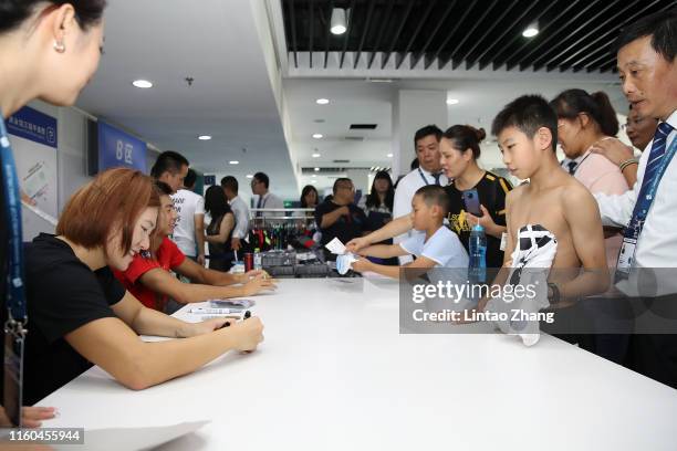 Ye Shiwen and Yan Zibei of China sign to fans at Speedp Booth on day 2 of the 2019 FINA Swimming World Cup at Jinan Olympic Sports Centre Stadium on...