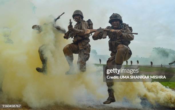 Indian Army recruits shout and jump next to colourful smoke during a training demonstration at the Jak Rifles regimental centre in Jabalpur in Madhya...