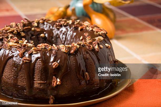chocolate cake covered with nuts - bundt cake stock pictures, royalty-free photos & images