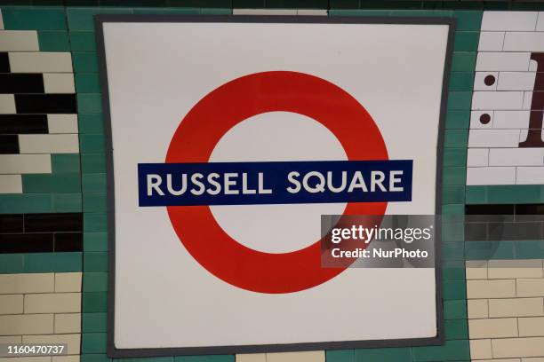 Russell Square tube station of London Underground in Borough of Camden. The station, train, rails, passengers and validation machine entrance as seen...