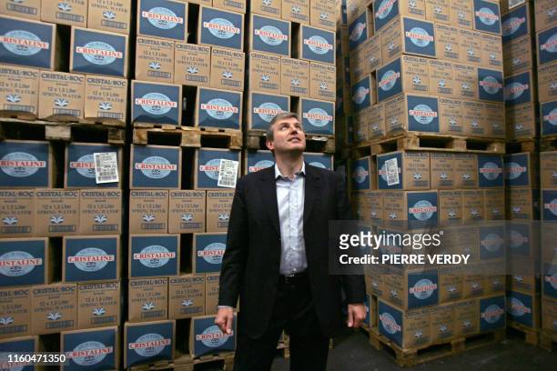 Roland Coutas, PDG du supermarché en ligne Telemarket.fr, pose au milieu des bouteilles d'eau le 10 avril 2007 à Pantin dans le centre de préparation...