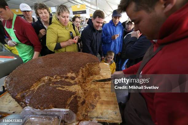 Vendor presents free cheesecake at the market during the Cheese Festival in Dubrovskoye, 45 km. West of Moscow, Russia, August 2019. 300 farmers and...