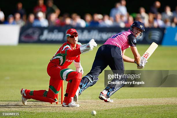 Ryan McLaren of Middlesex hits out watched by Mark Wallace of Glamorgan during the Friends Life T20 match between Middlesex and Glamorgan at Richmond...